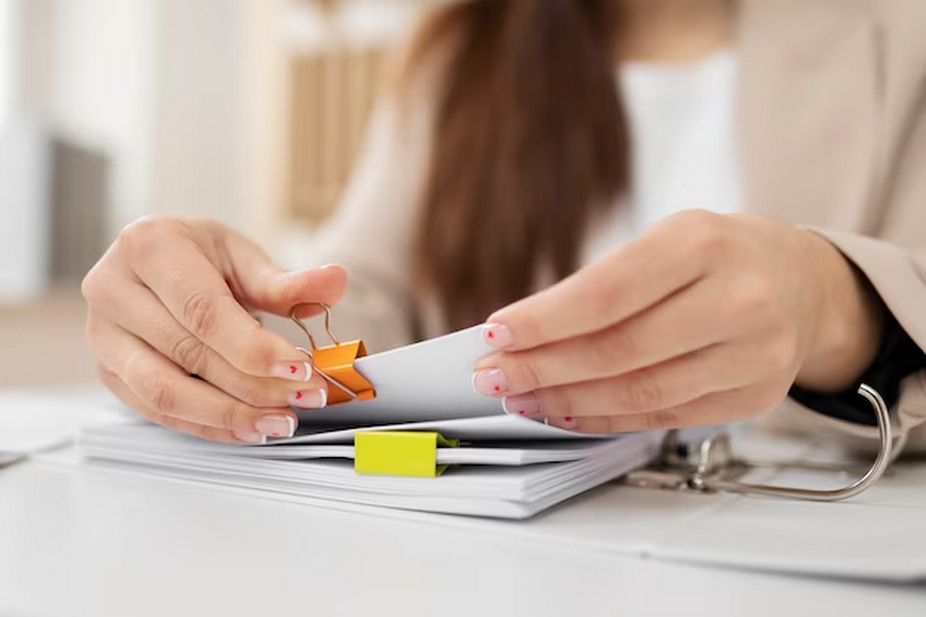 Woman clipping documents.